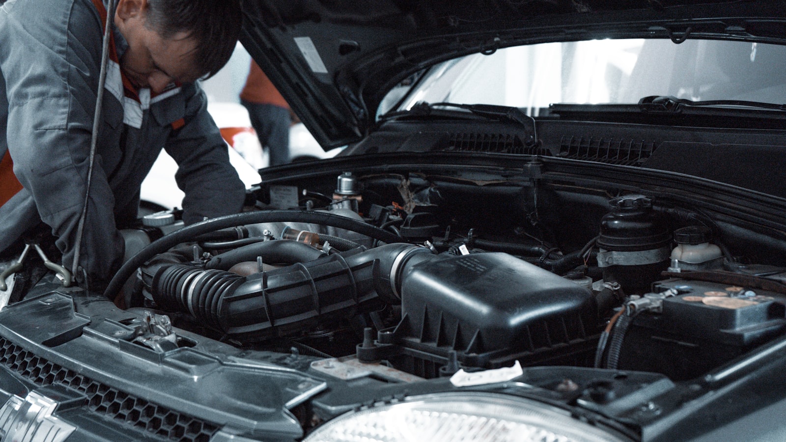 A technician checking under the hood of a car